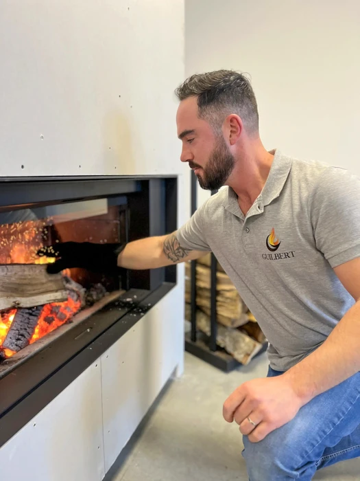 Intérieur résidentiel avec cheminée à foyer fermé en fonctionnement, flammes visibles à travers la vitre