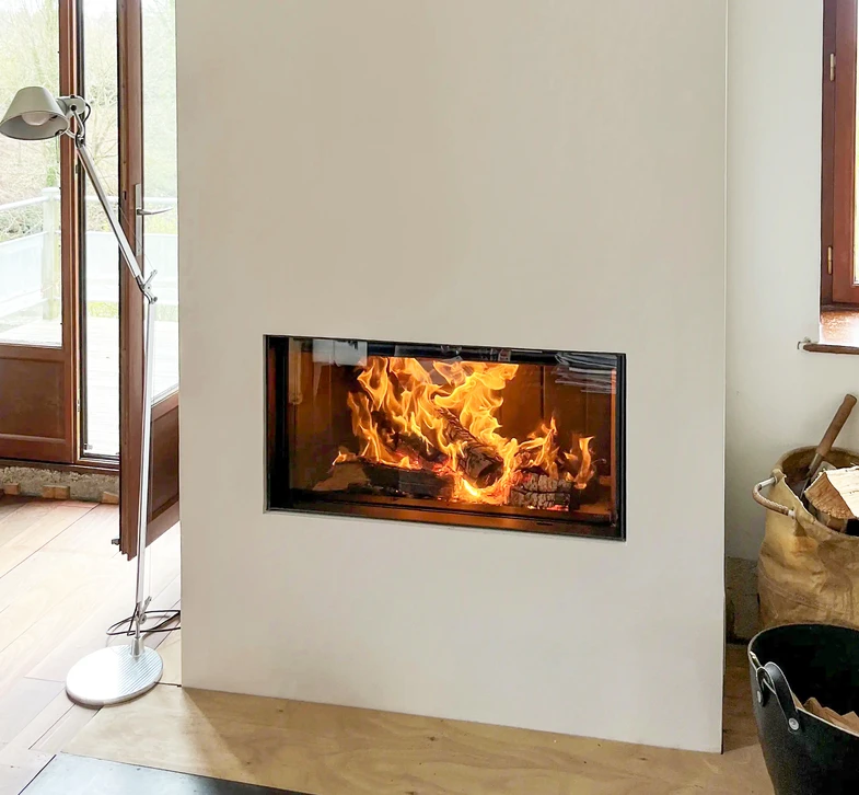 Intérieur résidentiel avec cheminée en briques rouges équipée d'un insert de chauffage au bois